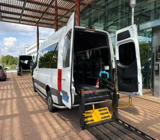 Professionele rolstoeltaxi chauffeur helpt klant in Schiphol